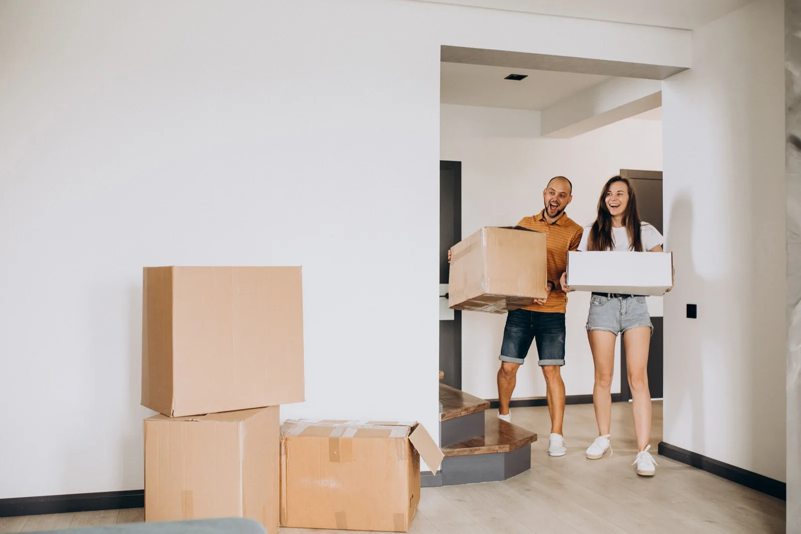 Couple emménageant dans un appartement neuf, cartons et pièces lumineuses — projet de résidence principale